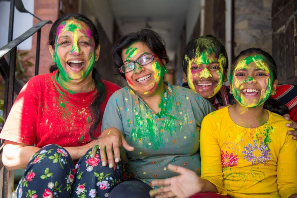 Happy Holi celebration with family throwing colorful gulal, vibrant Holi festival HD image